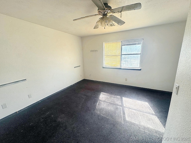 empty room with ceiling fan and a textured ceiling