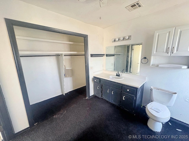 bathroom with visible vents, toilet, vanity, and carpet flooring