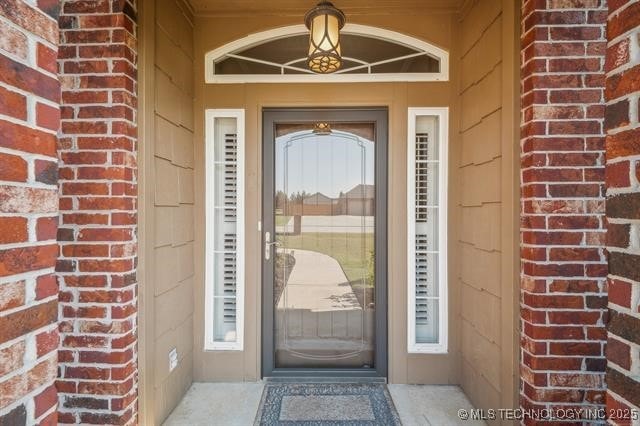 view of exterior entry with brick siding