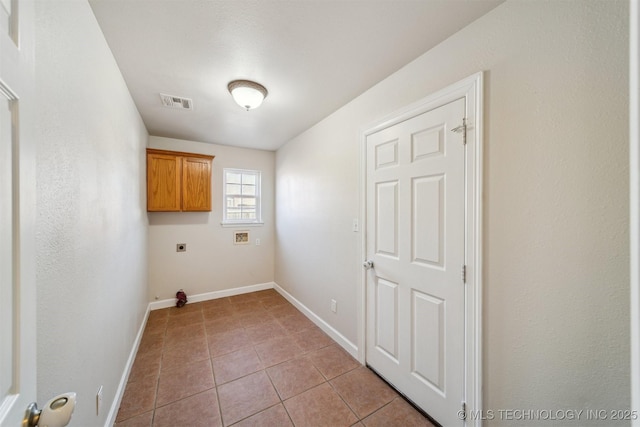 laundry room with visible vents, cabinet space, light tile patterned floors, baseboards, and hookup for an electric dryer