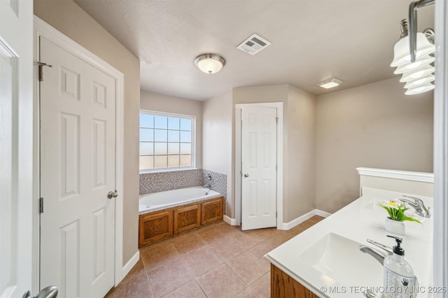 bathroom featuring baseboards, visible vents, a sink, tile patterned floors, and a bath