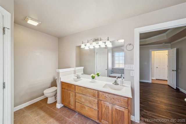 full bathroom featuring a sink, baseboards, ornamental molding, and double vanity