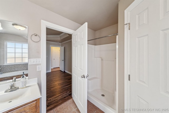 full bath with tile patterned floors, vanity, crown molding, and walk in shower