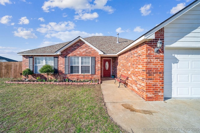 view of front of house with a front lawn, fence, roof with shingles, a garage, and brick siding