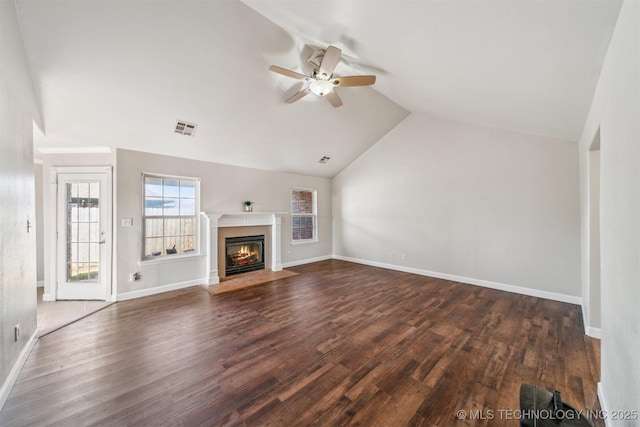 unfurnished living room with visible vents, a fireplace with flush hearth, dark wood finished floors, and vaulted ceiling