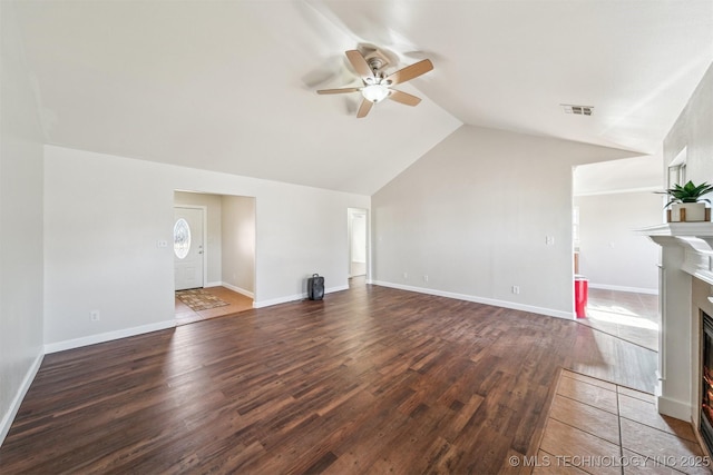 unfurnished living room featuring visible vents, a fireplace with flush hearth, wood finished floors, lofted ceiling, and ceiling fan