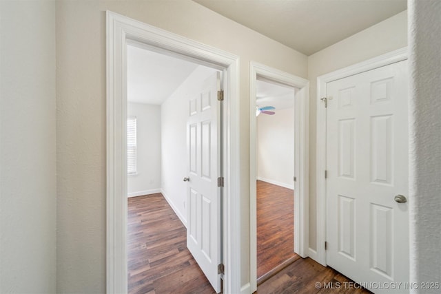 hall with baseboards and dark wood-style flooring