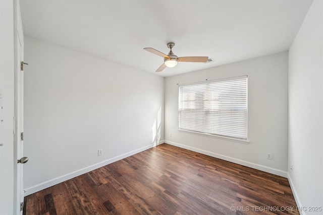 empty room featuring a ceiling fan, visible vents, wood finished floors, and baseboards