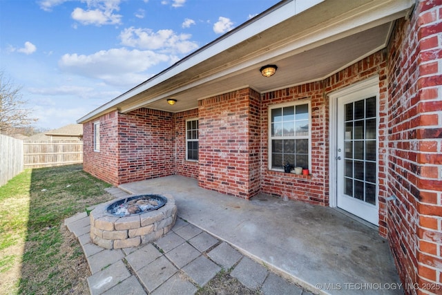 view of patio featuring an outdoor fire pit and fence