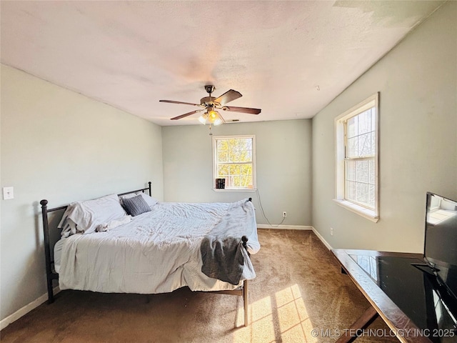 carpeted bedroom featuring baseboards and ceiling fan