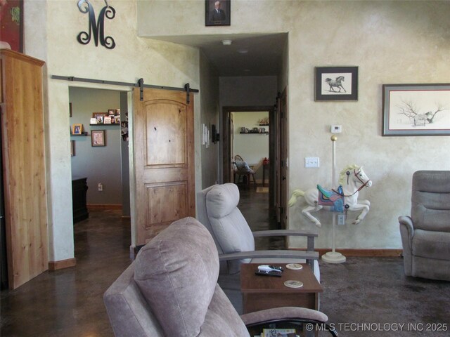 living room featuring a barn door and baseboards