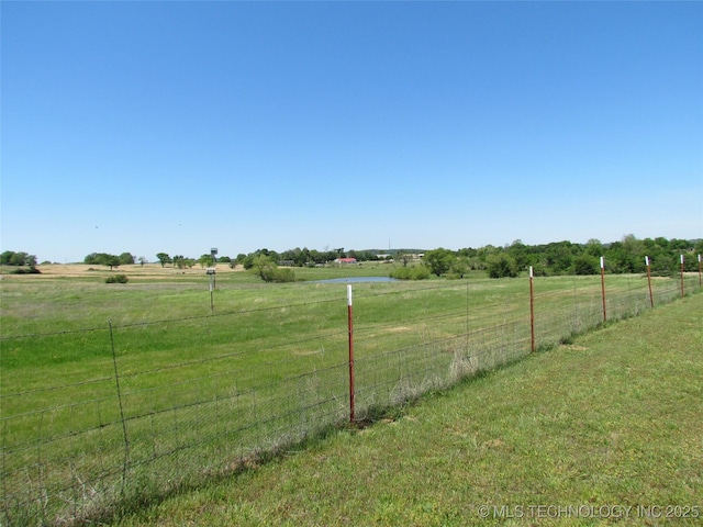 view of yard featuring a rural view and fence