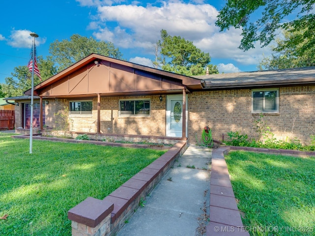 single story home with brick siding and a front yard