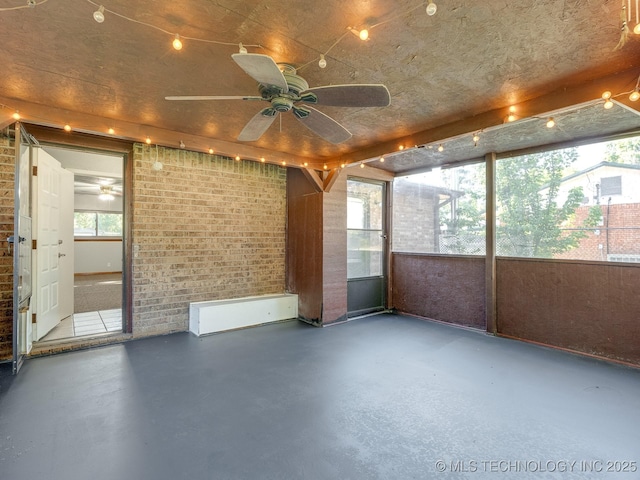 unfurnished sunroom with a ceiling fan