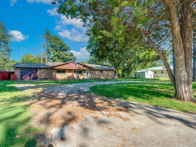 ranch-style home featuring brick siding, driveway, a front lawn, and fence