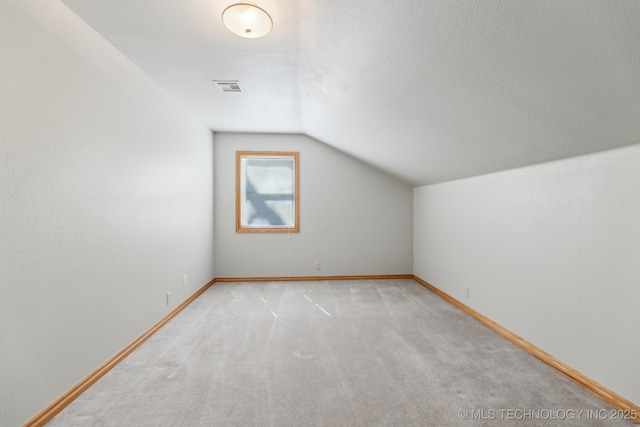 bonus room with visible vents, baseboards, carpet, vaulted ceiling, and a textured ceiling