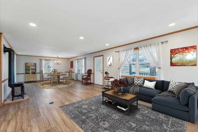 living area featuring recessed lighting, an inviting chandelier, wood finished floors, and ornamental molding