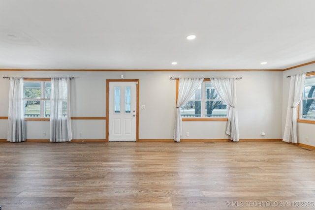 interior space featuring recessed lighting, baseboards, light wood-style floors, and ornamental molding