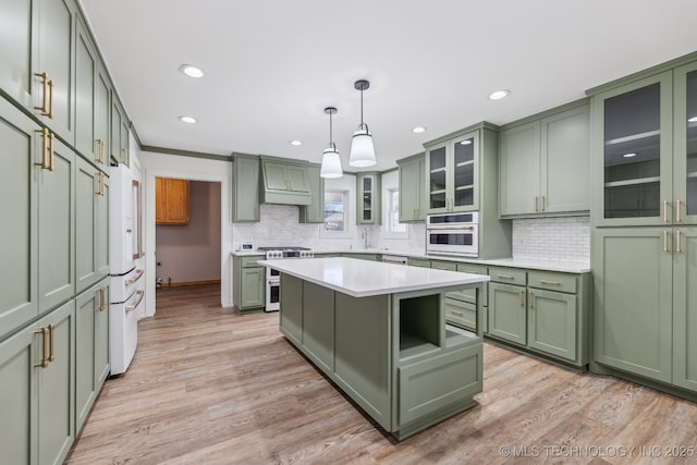 kitchen with white appliances, light wood-type flooring, light countertops, and green cabinetry