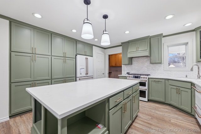 kitchen with green cabinets, open shelves, high quality appliances, and a sink