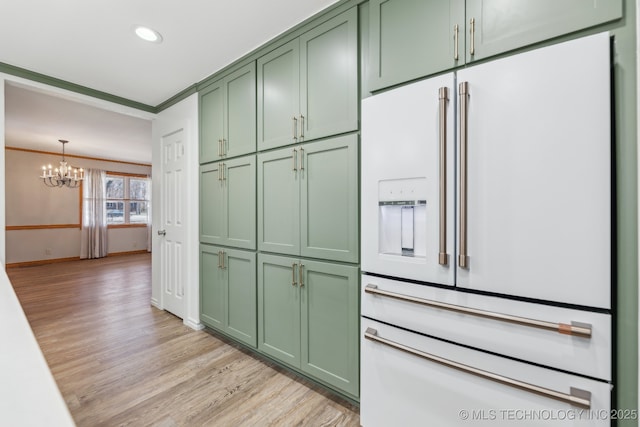 kitchen featuring green cabinets, light wood-type flooring, ornamental molding, high end white refrigerator, and an inviting chandelier