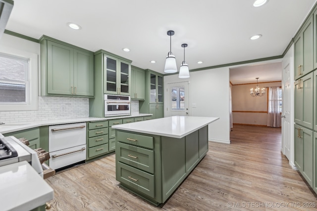 kitchen featuring green cabinetry, oven, light wood-style floors, and light countertops