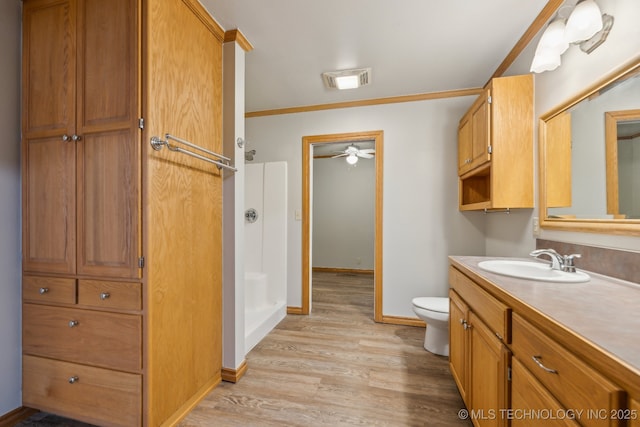 bathroom featuring visible vents, toilet, wood finished floors, vanity, and a ceiling fan