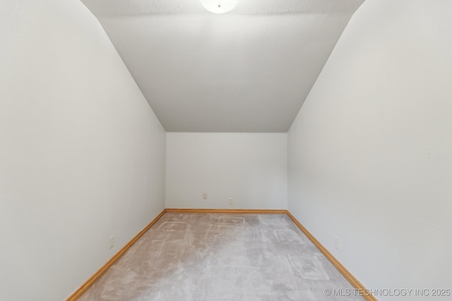 bonus room featuring baseboards, light carpet, and lofted ceiling