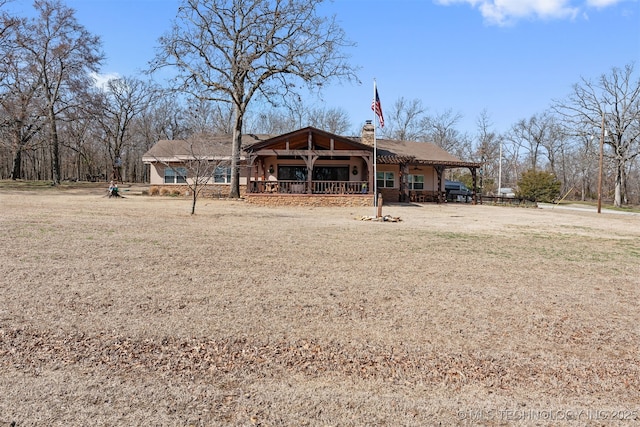 view of front facade with dirt driveway and a chimney