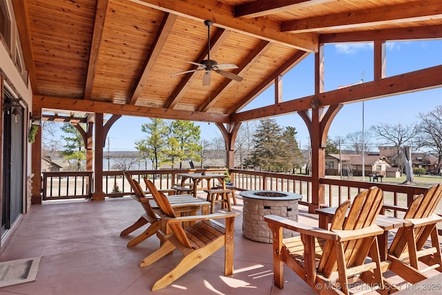 wooden terrace featuring an outdoor fire pit and a ceiling fan