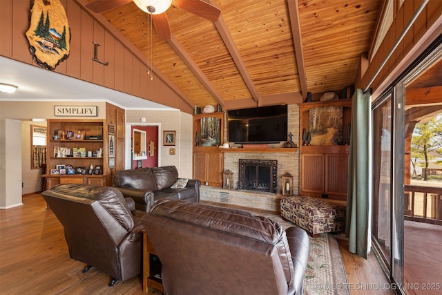 living area with beamed ceiling, wooden ceiling, a fireplace, and wood finished floors