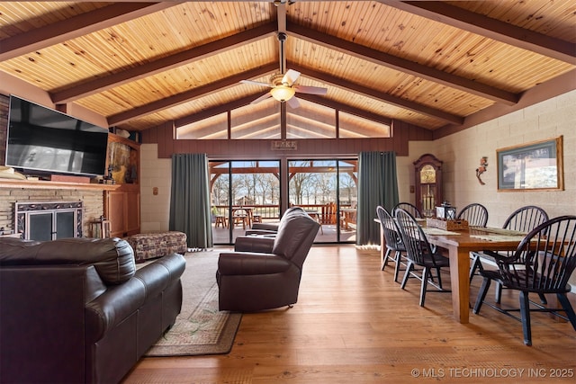 living room featuring lofted ceiling with beams, wood ceiling, a ceiling fan, and hardwood / wood-style flooring