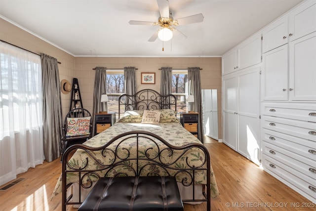 bedroom with light wood-type flooring, visible vents, and a ceiling fan