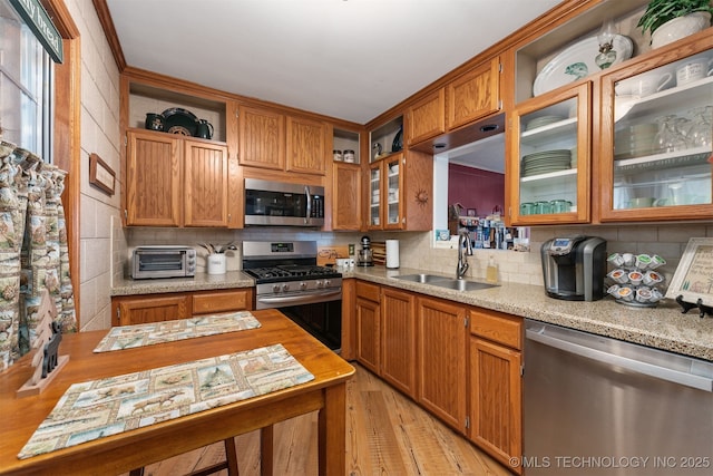 kitchen with a sink, stainless steel appliances, open shelves, and tasteful backsplash