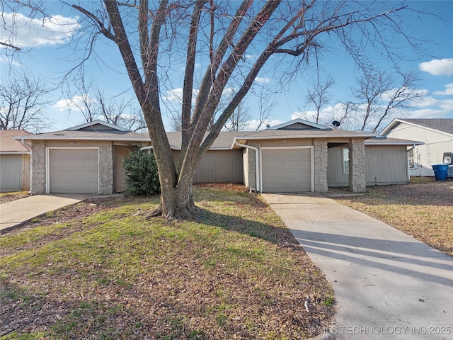 view of front facade with stone siding, an attached garage, driveway, and a front yard