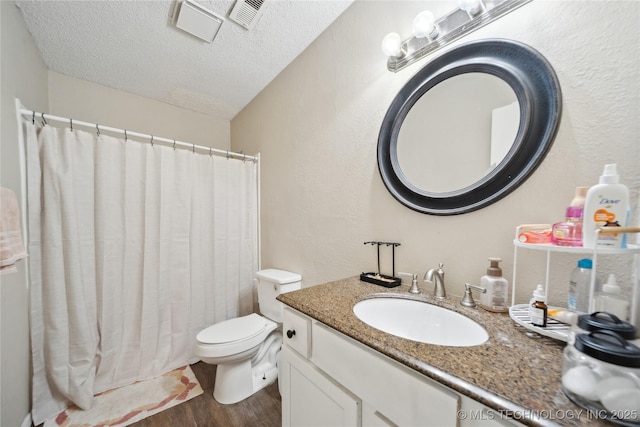 full bath with visible vents, toilet, a textured ceiling, wood finished floors, and a textured wall