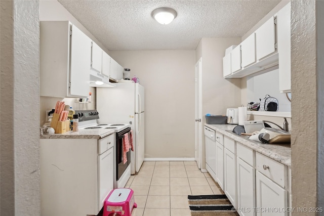 kitchen with light countertops, a textured ceiling, light tile patterned floors, white appliances, and white cabinetry