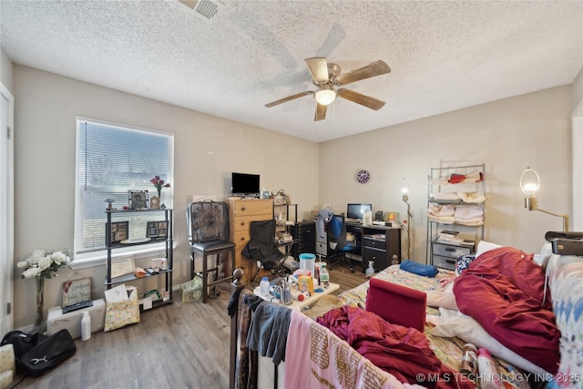 interior space with a textured ceiling, wood finished floors, and a ceiling fan