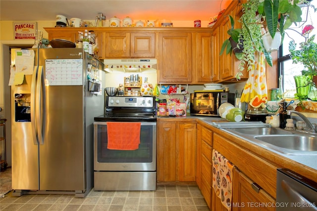 kitchen with a sink, stainless steel appliances, brown cabinets, and extractor fan