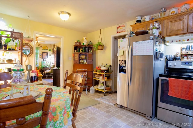 kitchen with under cabinet range hood, stainless steel appliances, and brown cabinets