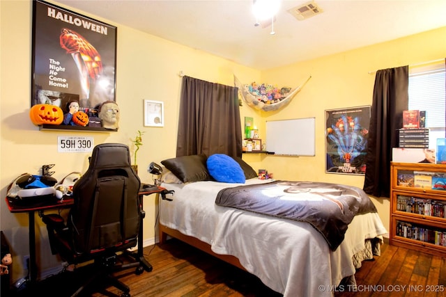 bedroom featuring visible vents and wood finished floors