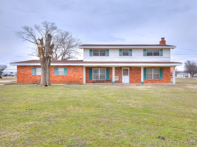 traditional-style home with a front yard, brick siding, and a chimney