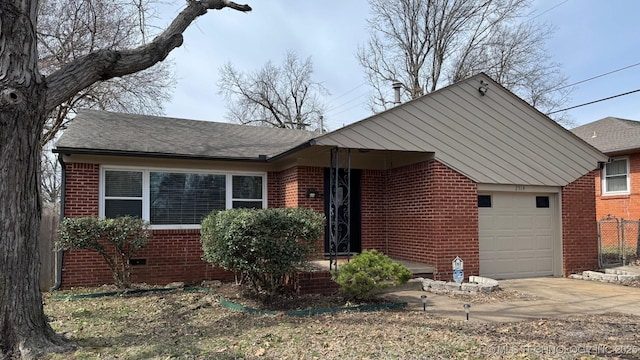 view of front of house with roof with shingles, an attached garage, concrete driveway, crawl space, and brick siding