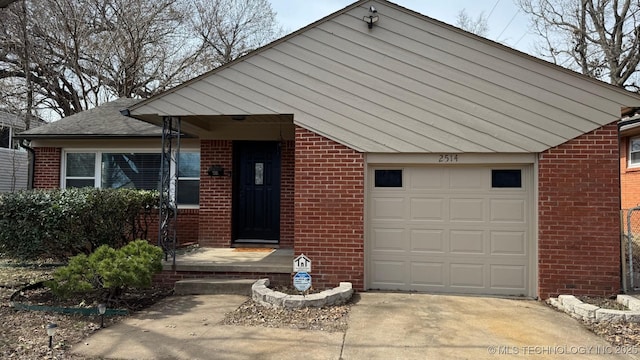 view of front of property featuring a garage, brick siding, and concrete driveway