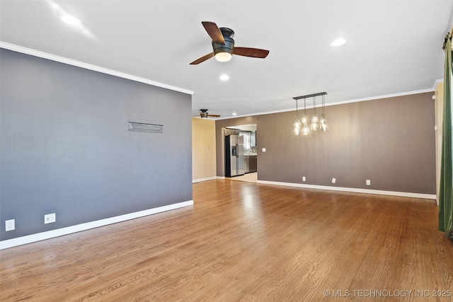 unfurnished living room featuring wood finished floors, baseboards, recessed lighting, ornamental molding, and ceiling fan with notable chandelier