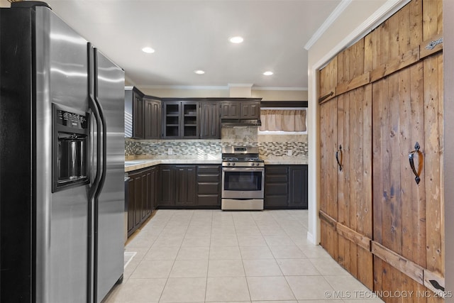 kitchen with under cabinet range hood, tasteful backsplash, appliances with stainless steel finishes, light countertops, and light tile patterned floors