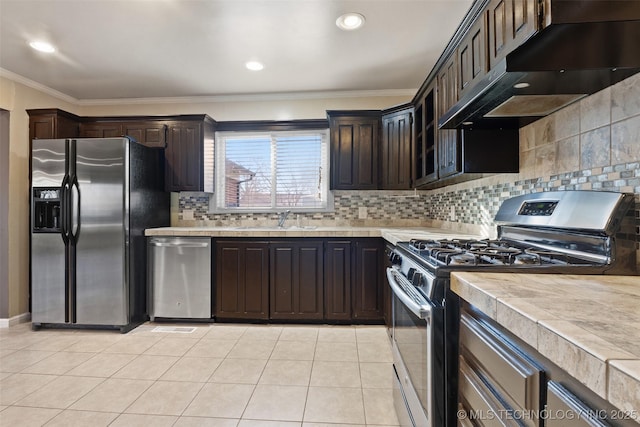 kitchen with under cabinet range hood, dark brown cabinetry, light countertops, appliances with stainless steel finishes, and a sink