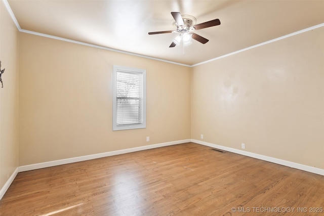 spare room featuring visible vents, crown molding, baseboards, wood finished floors, and a ceiling fan