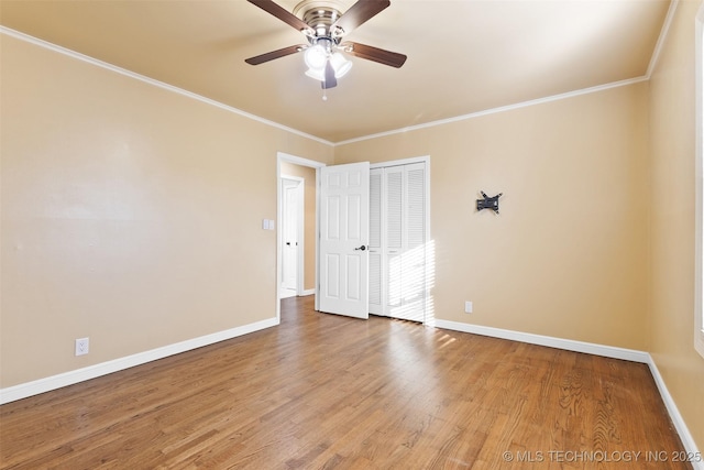 spare room featuring wood finished floors, baseboards, and ornamental molding