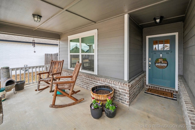 entrance to property with brick siding and covered porch